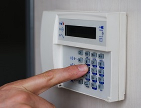 Finger Pressing Keys On Alarm Keypad