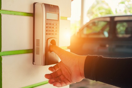 Person's hand pushing on a biometric access control system